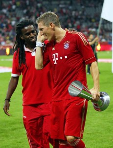 Schweinsteiger, com o trofeu de 2º colocado, conversa com Tinga, do Inter