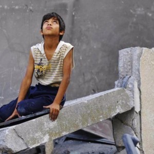 Menino palestino nos destroços de um prédio destruído em Gaza - MOHAMMED ABED / AFP