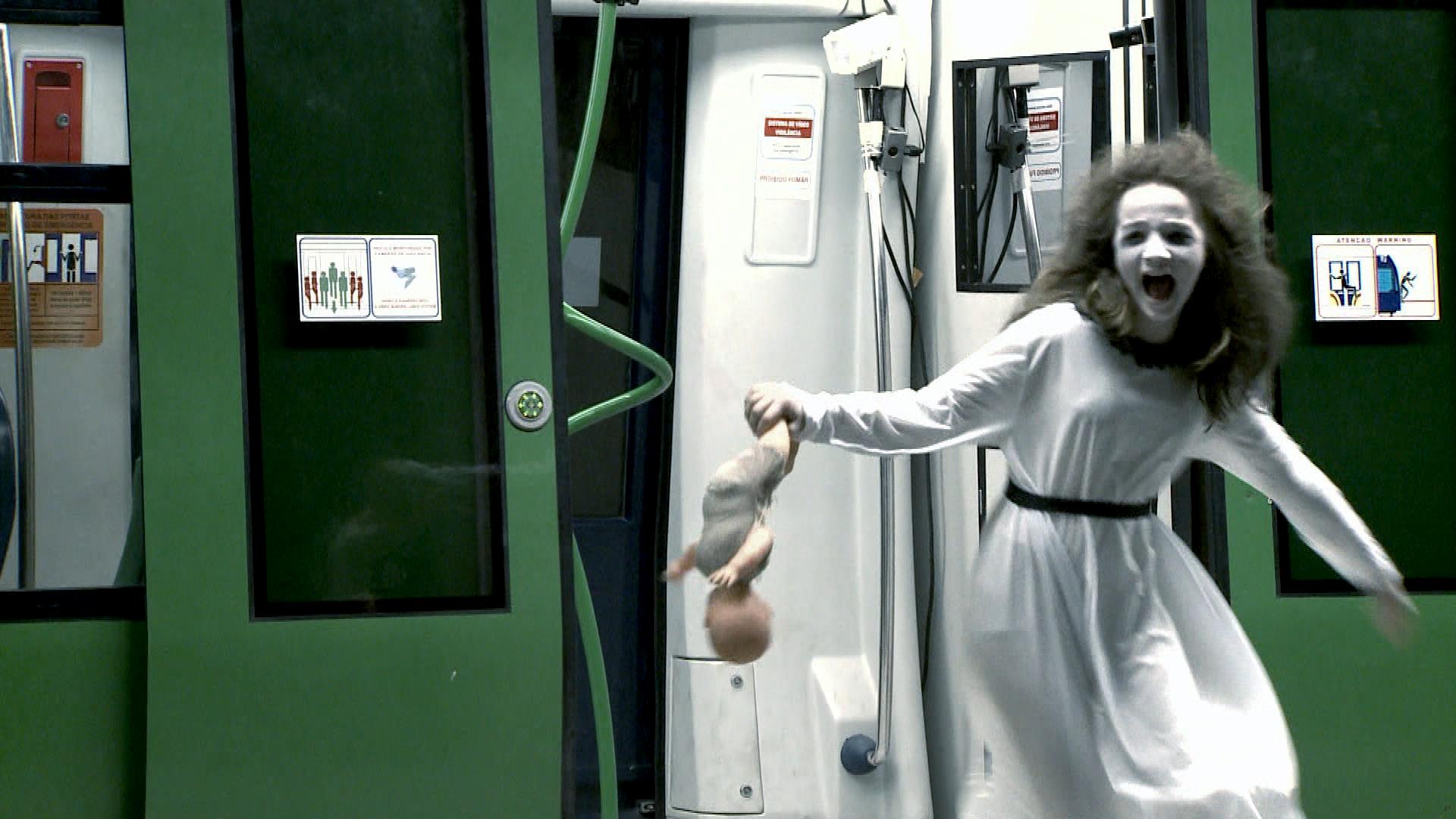 A "Menina Fantasma" aterrorizando passageiros no metrô, no ano passado (Fotos Divulgação/SBT)